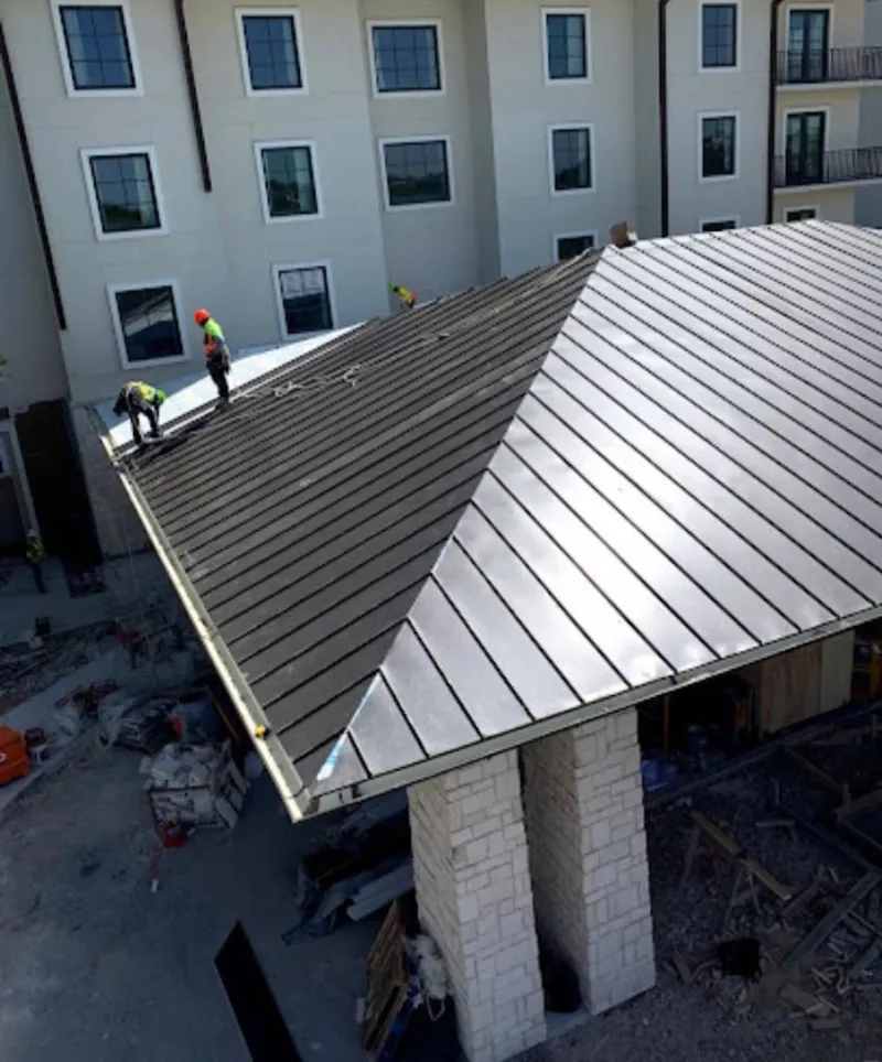 Crew installing standing seam metal roof panels on a commercial project in Lexington Park